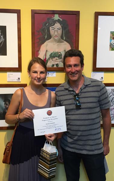 Kristina and Mr. Locascio, Art teacher, stand in front of Kristinas artwork.