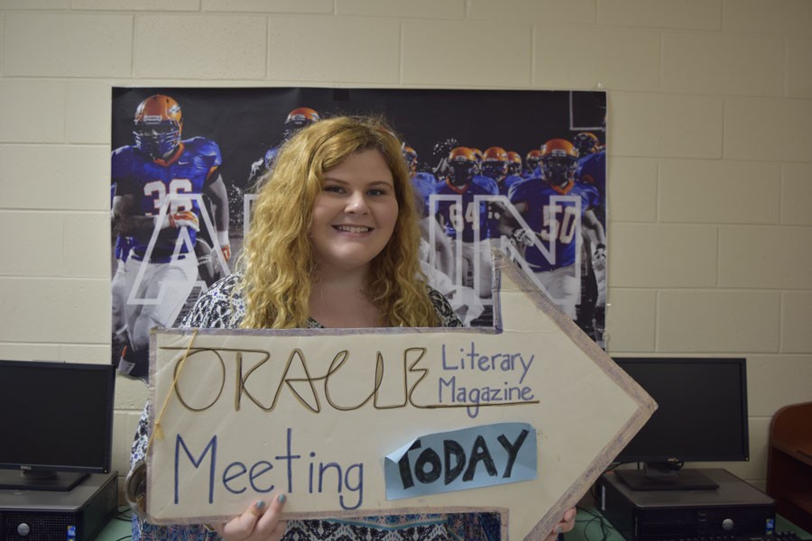 Oracle editor Madison Murphy proudly holds the sign that indicates Monday meetings.