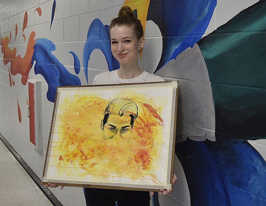 Erin Stein holds her artwork selected for display.