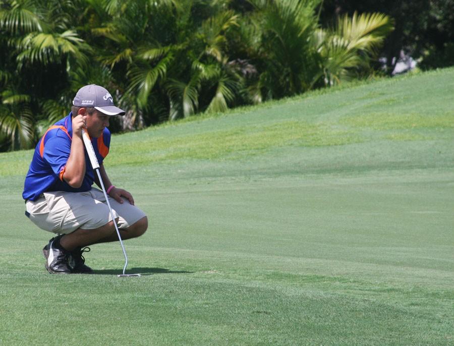 Connor Hill, 12th grade, reads the putt. 