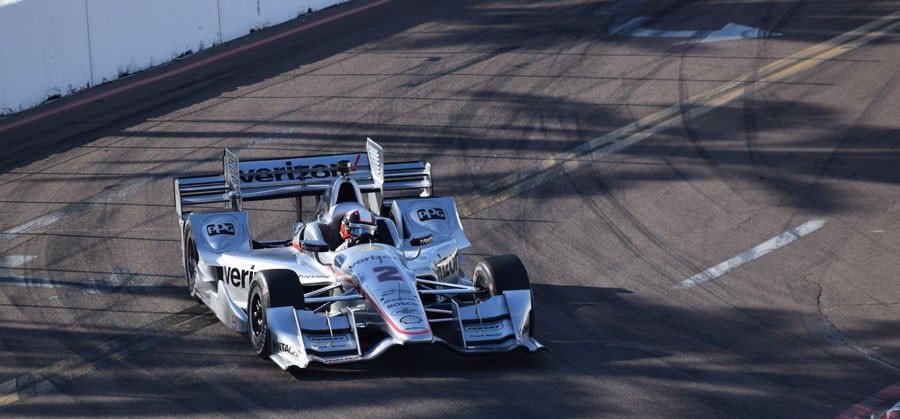 During practice day, Juan Pablo Montoya makes a turn around Dan Wheldon Way.