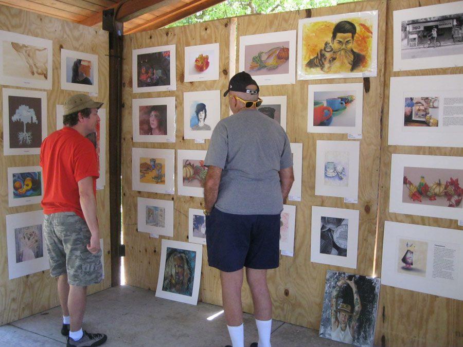 Art teacher Mr. LoCascio explains his students' art works to a visitor who stopped by the Osceola booth.