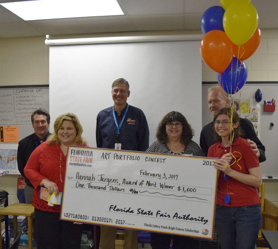 Hannah Jurgens holds her scholarship check.