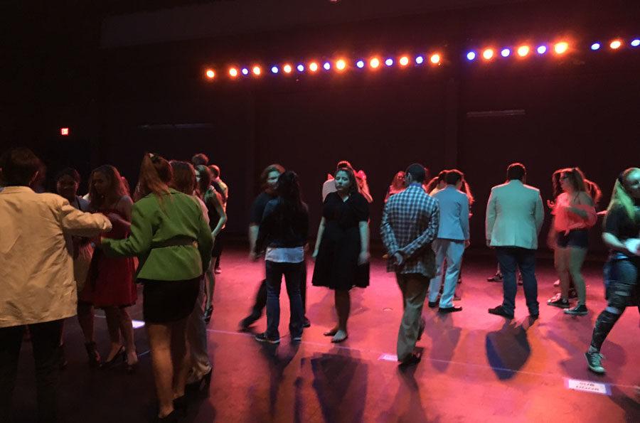 Students danced on the stage in the theater while popular 80’s songs were playing. 