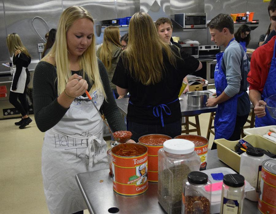 Students make spaghetti to prepare for Friday's event.