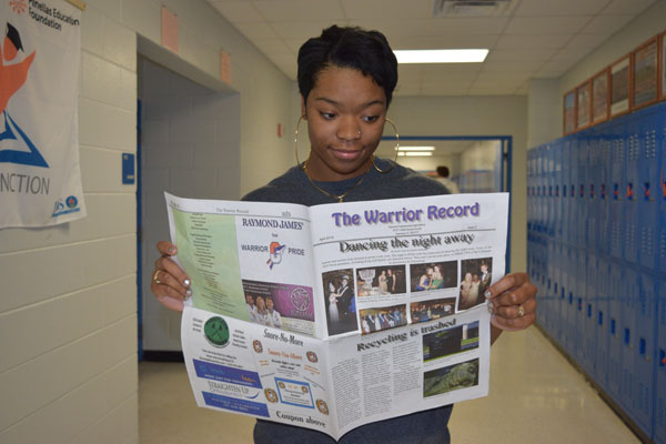 Amari Williams shows off the latest edition of the school newspaper.