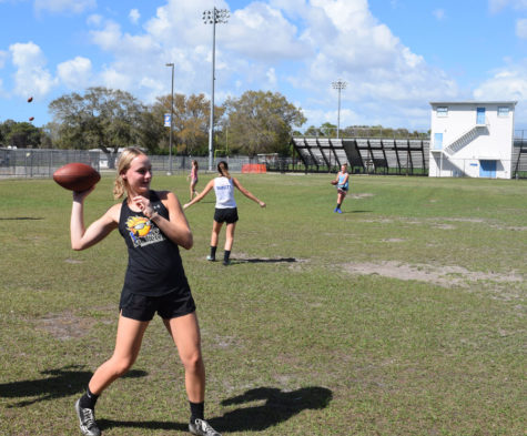Grace Thrower throws a football to teammates in 2019.