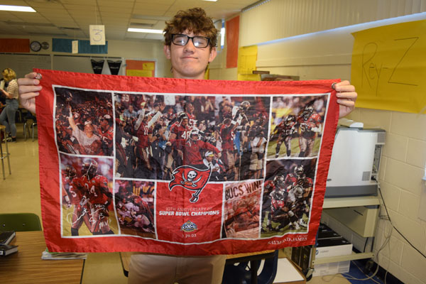 Ethan Tuttle holds up the Bucs Super Bowl flag from 2003.