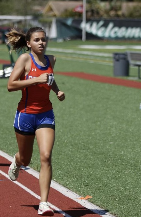 Osceola track student running during a meet while competing in districts.