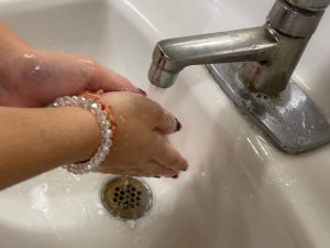 Student washing her hands to stay healthy during sick season.