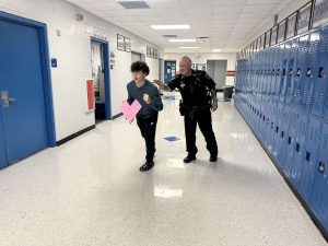 Student running from Deputy Funk with a heart for Valentines Day.