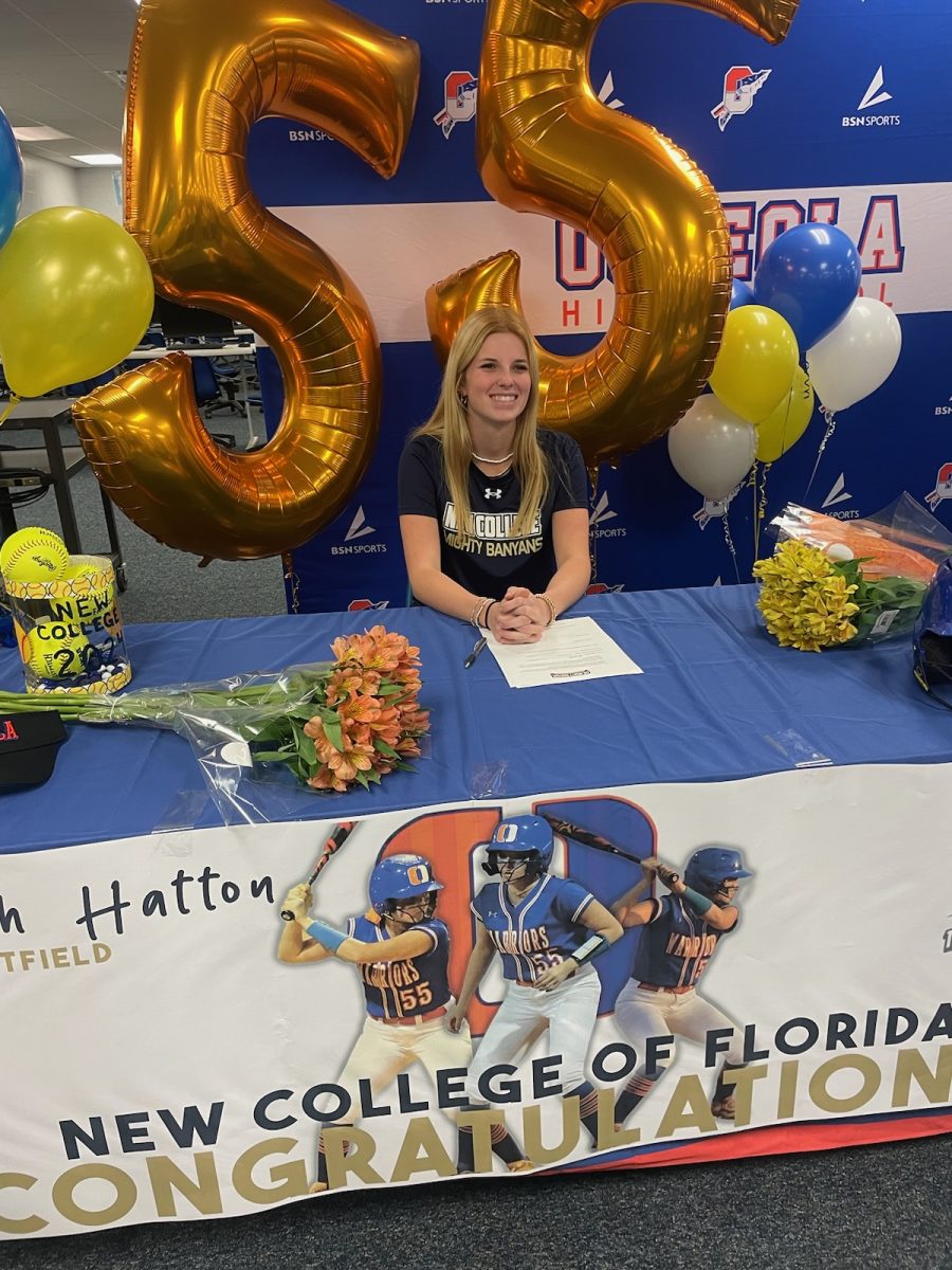 Hannah Hatton signing for a softball scholarship at New College of Florida. 