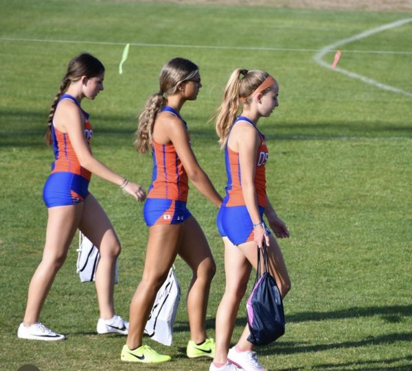 Three girls on the girls Warriors track team walk together at one of their last meets last year.