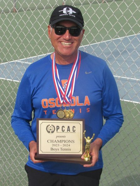 The boys tennis team had an undefeated 2023-2024 season. Coach Lense holds the winning plaque.