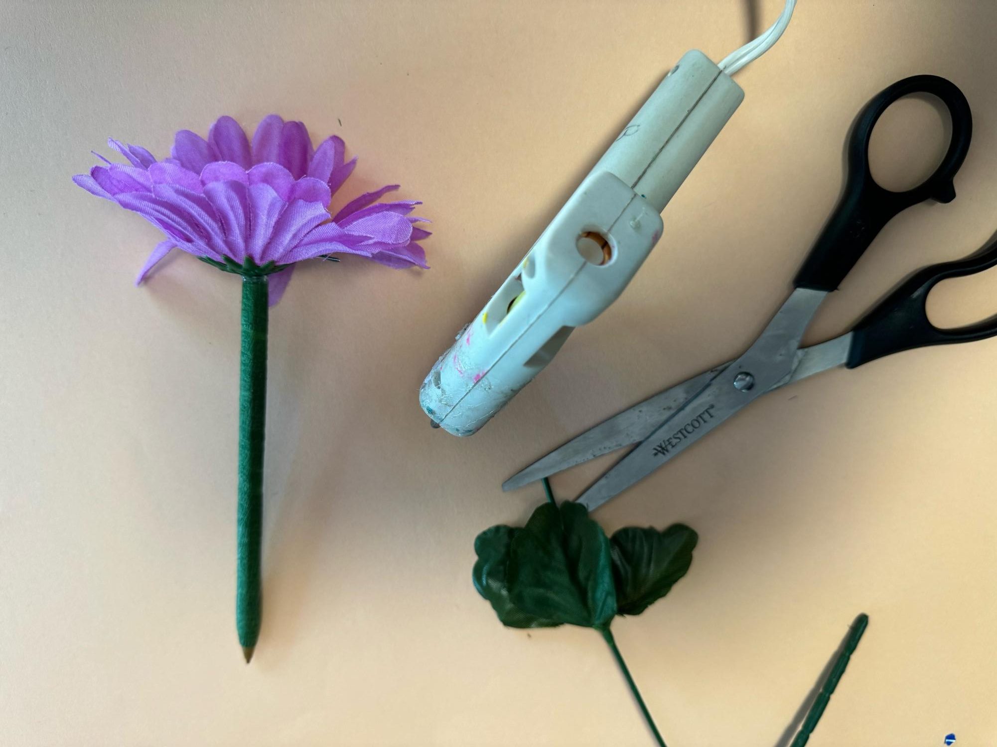 Step 3: cut a flower off its stem and glue it to the pen.