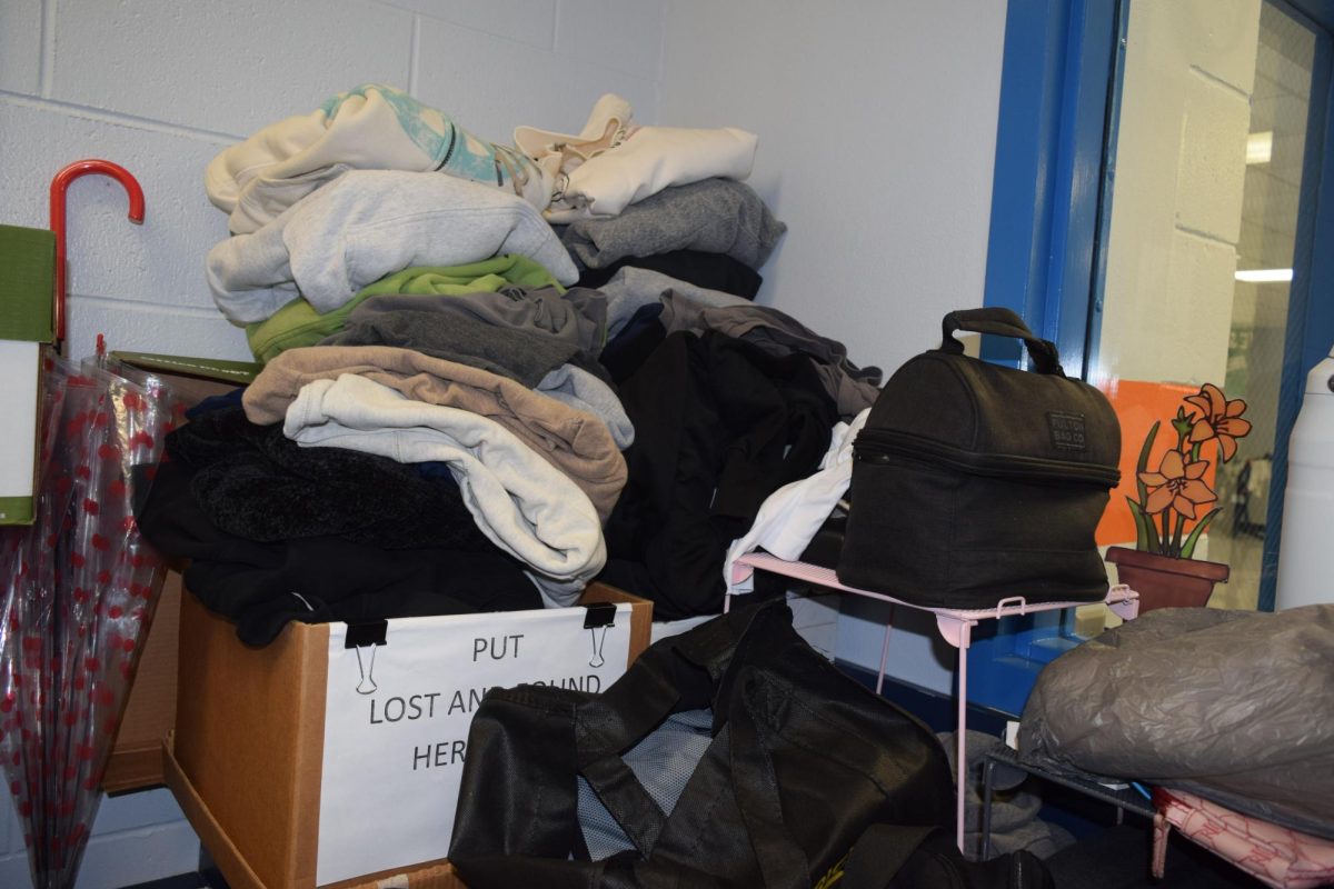Many sweaters and jackets are piled high.