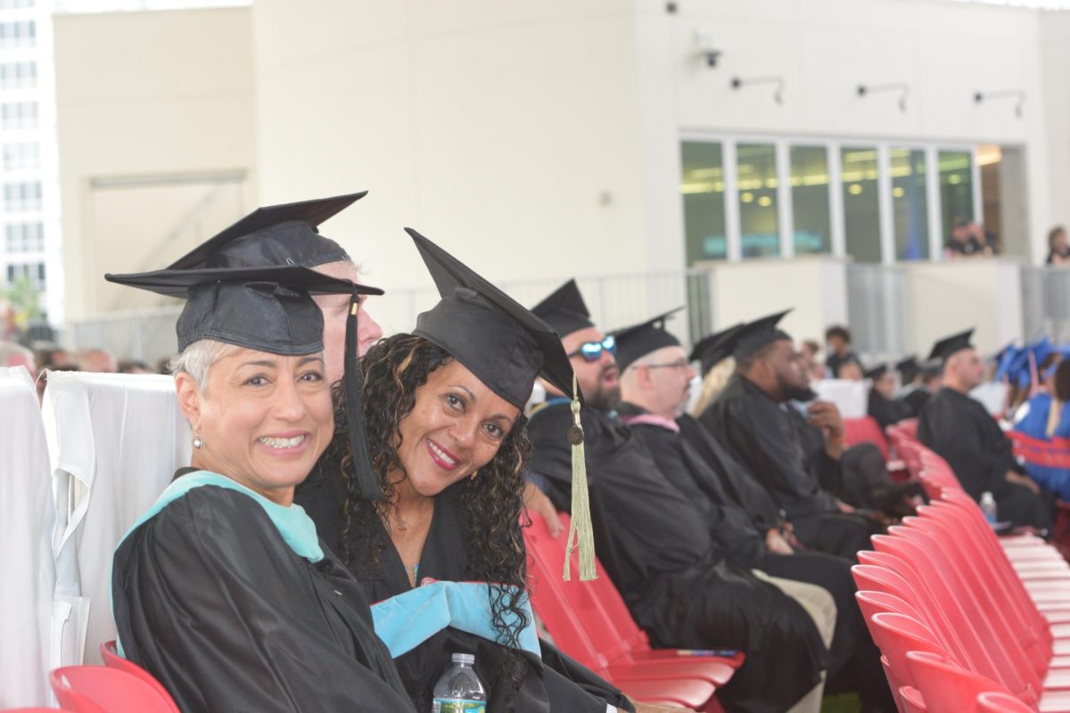 (8:00 a.m.) Faculty and staff members sat behind the senior class as they listened to the speakers.